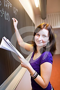 College student writing on the chalkboard