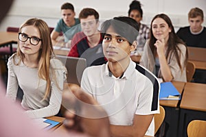 College Students In Class Viewed From Behind Teacher