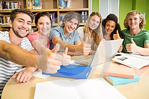 College students gesturing thumbs up in library