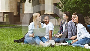 College students having discussion in campus on grass