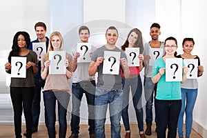 College students holding question mark signs