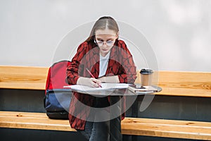 College students mental health. Sad and frustrated teenager student girl sitting with laptop and books