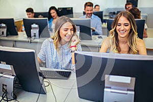 College students sitting in a classroom, using computers