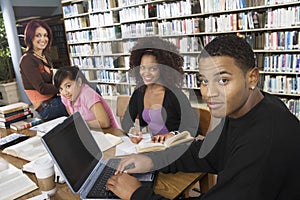 College Students Studying Together In Library