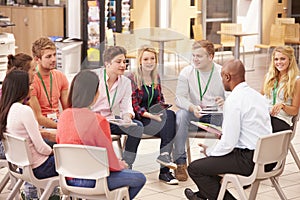 College Students With Tutor Having Discussion