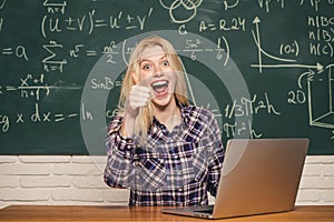 College tutor. Portrait of a happy female student using laptop computer in university. Student working on laptop in