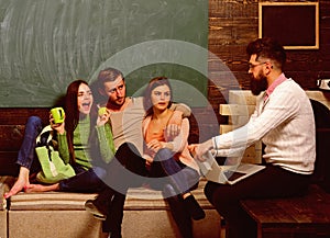 College and university concept. Students, scientists studying , professor holds laptop, teaches, explains, chalkboard