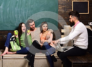 College and university concept. Students, scientists studying , professor holds laptop, teaches, explains, chalkboard