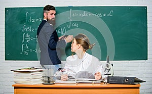 College university education. High school. Solving task. Man writing on chalkboard math formulas. Teaching in university
