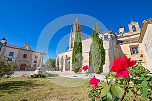 Ancient cross and San Miguel Collegiate in Ampudia village photo