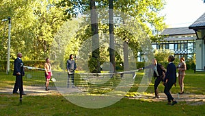 Collegues play badminton in the courtyard together.