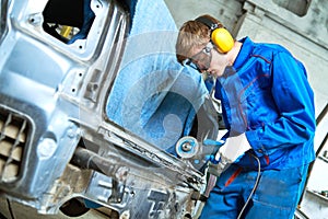 Collision repairs service. mechanic grinding car body by grinder