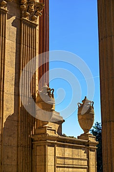 Colloseum style structure or building with orange clay color and decorative vases on wall of house with sky background