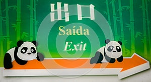 Exit sign in three languages, english, portuguese and chinese, with two panda bears