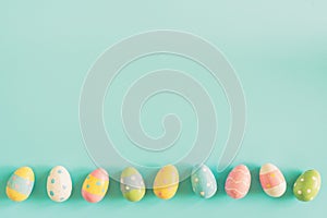 Coloeful easter eggs on pastel color background with space.