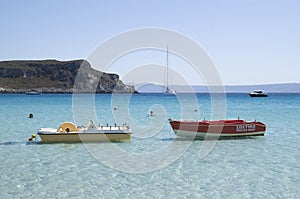 Coloful water wheels, rescue boat, motorboat and yacht in a quiet bay Simos in Greece