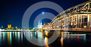 Cologne Cathedral and Hohenzollern Bridge at sunset, nighttime. Photo for postcard