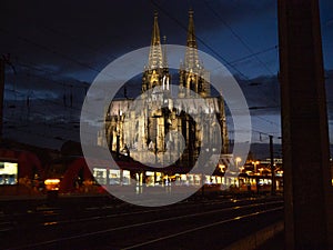 Cologne cathedral at night with a train passing through.