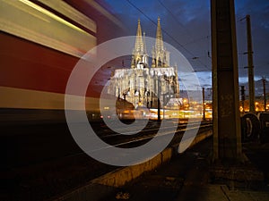 Cologne cathedral at night with a train passing through.