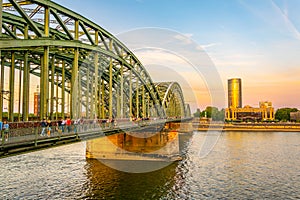 COLOGNE, GERMANY, AUGUST 11, 2018: People are passing on Hohenzollern bridge over Rhein during sunset, Germany