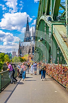 COLOGNE, GERMANY, AUGUST 11, 2018: People are passing on Hohenzollern bridge over Rhein during sunset, Germany