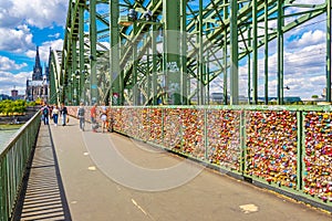 COLOGNE, GERMANY, AUGUST 11, 2018: People are passing on Hohenzollern bridge over Rhein during sunset, Germany