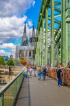 COLOGNE, GERMANY, AUGUST 11, 2018: People are passing on Hohenzollern bridge over Rhein during sunset, Germany