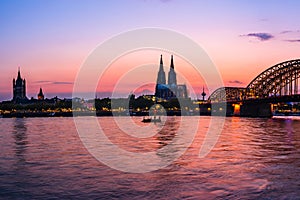 Evening silhouette skyline landscape of the gothic Cologne Cathedra, Hohenzollern railway and pedestrian bridge, the old town and