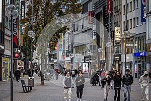 COLOGNE, GERMANY - NOVEMBER 5, 2022: crowd of people walking on schildergasse street with stores and german kids walking.