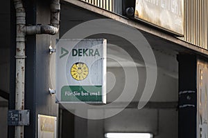 COLOGNE, GERMANY - NOVEMBER 11, 2022: Logo of Dekra in front of one of their offices. Dekra is a German chain specialized in