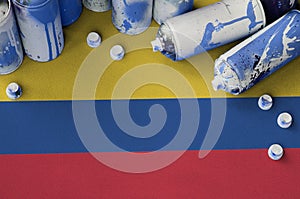 Colombia flag and few used aerosol spray cans for graffiti painting. Street art culture concept photo