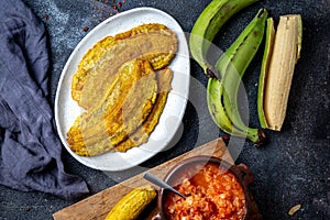 COLOMBIAN CARIBBEAN CENTRAL AMERICAN FOOD. Patacon or toston, fried and flattened whole green plantain banana on white