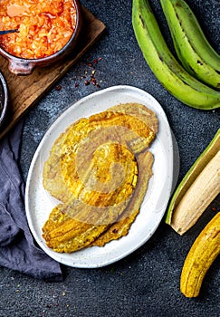 COLOMBIAN CARIBBEAN CENTRAL AMERICAN FOOD. Patacon or toston, fried and flattened whole green plantain banana on white