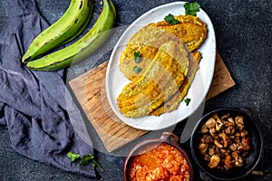 COLOMBIAN CARIBBEAN CENTRAL AMERICAN FOOD. Patacon or toston, fried and flattened whole green plantain banana on white