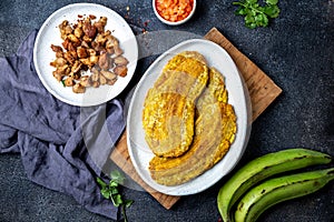 COLOMBIAN CARIBBEAN CENTRAL AMERICAN FOOD. Patacon or toston, fried and flattened whole green plantain banana on white