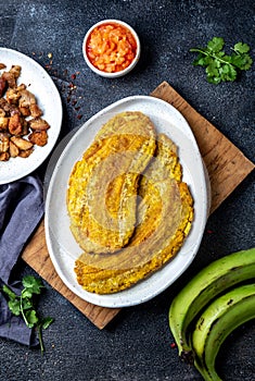 COLOMBIAN CARIBBEAN CENTRAL AMERICAN FOOD. Patacon or toston, fried and flattened whole green plantain banana on white