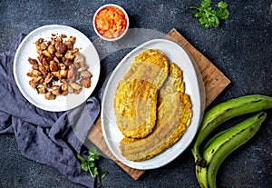 COLOMBIAN CARIBBEAN CENTRAL AMERICAN FOOD. Patacon or toston, fried and flattened whole green plantain banana on white