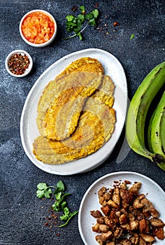 COLOMBIAN CARIBBEAN CENTRAL AMERICAN FOOD. Patacon or toston, fried and flattened whole green plantain banana on white