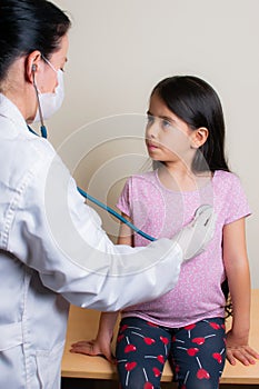 Colombian girl is examined by her pediatrician in the consulting room