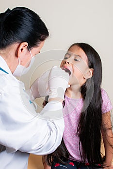 Colombian girl is examined by her pediatrician in the consulting room