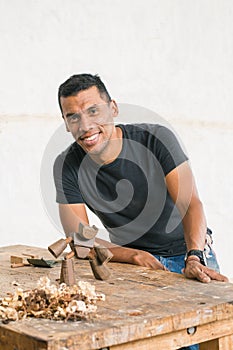 Colombian man in his workshop. carpenter using his tools to make pieces of wood.