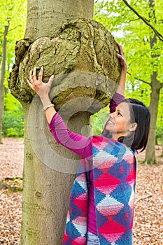 Woman holding cancerous tumor on beech tree photo