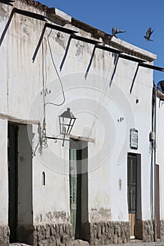 Colonial architecture in Cachi, blue sky and birds. Argentina