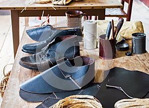 Colonial cobbler`s work bench with shoes in progress