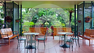 Colonial furnitures on a balcony against a tropical rain forest photo