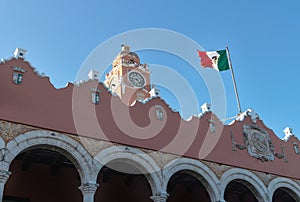 Colonial Olimpo Cultural Center with tower and blown flag on cloudless blue sky, Merida, Yucatan, Mexico photo