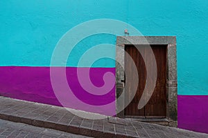 Colonial style wooden Door with colorful walls in Guanajuato Mexico.