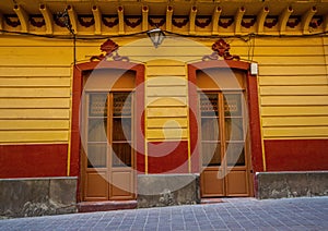 Colonial style wooden door with yellow wall in Guanajuato Mexico.