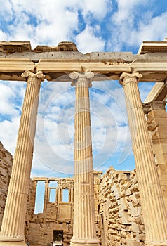 Colonnade of the Erechtheion temple in the Greek ancient Athenian Acropolis against the blue sky with clouds