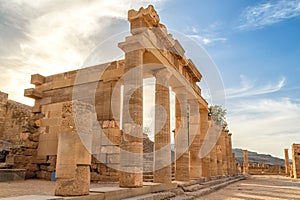 Colonnade with portico main temple of Lindos Rhodes on the background of sunset clouds and the sun